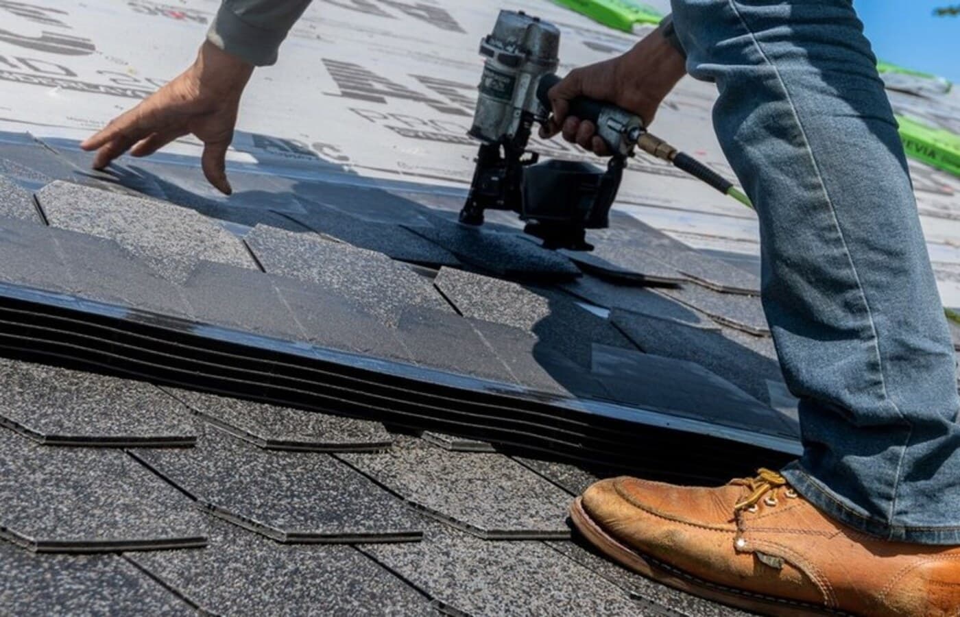 Representative roofing installation close-up showing underlayment, shingle courses, and fastening work